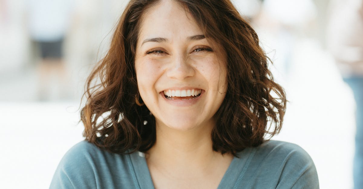 A middle-aged Portuguese woman smiling while holding a small white pill and a glass of water in a bright kitchen, natural daylight, health and wellness concept, realistic photography