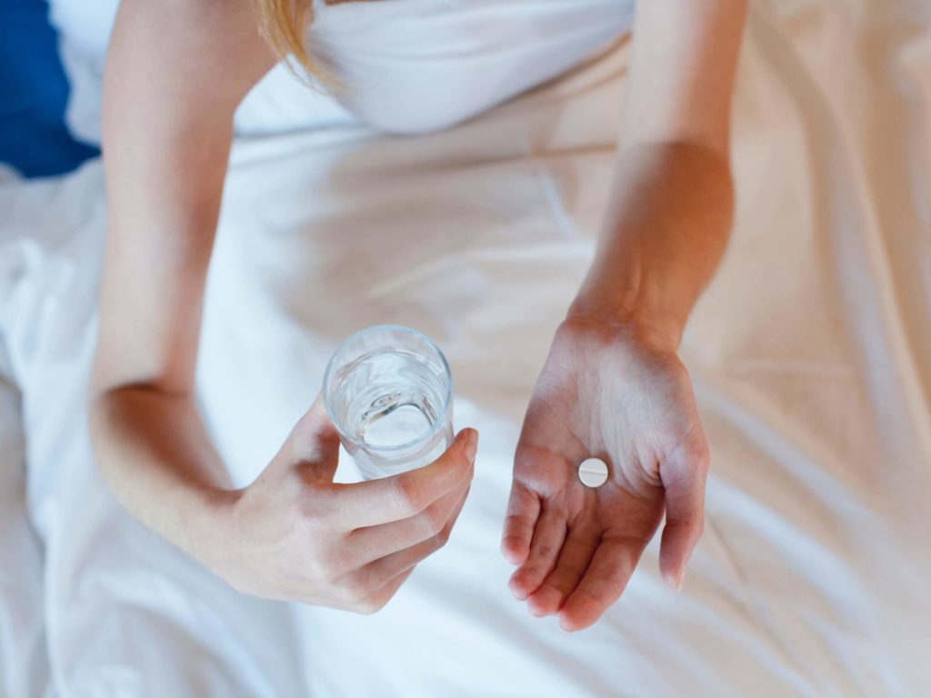 Mulher com água e comprimido